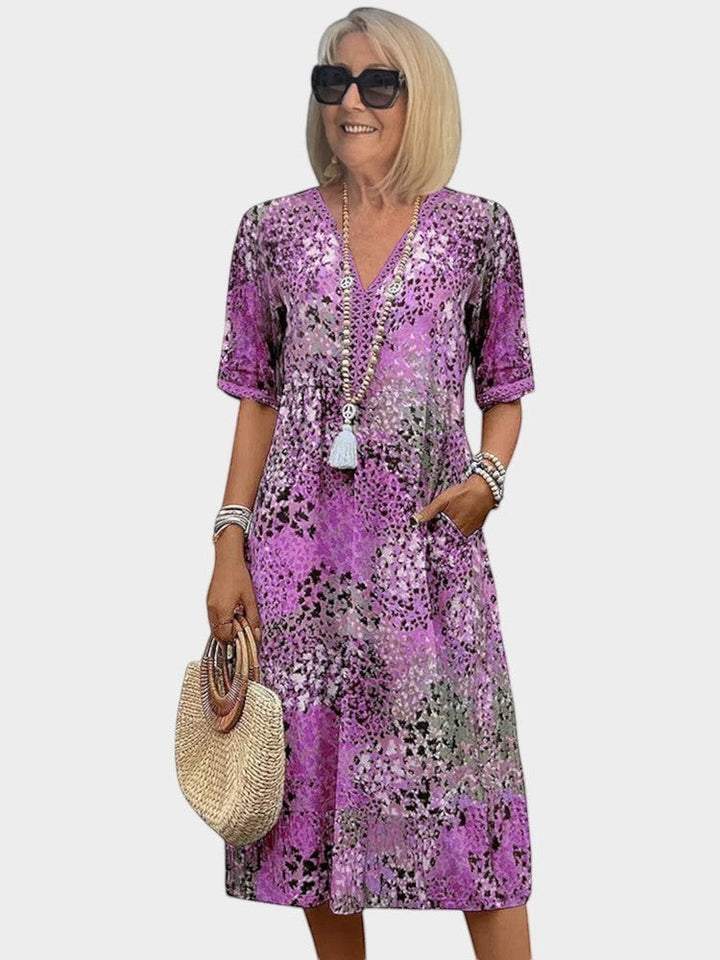 Victoria Boutique Lauren midi dress in fuchsia abstract print with V-neckline, lace trim, and side pockets.