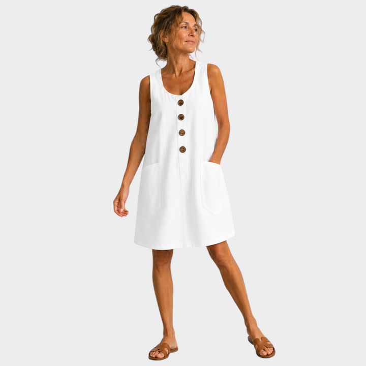 Victoria Boutique white cotton linen summer dress with U-neckline, decorative buttons, and side pockets on a model